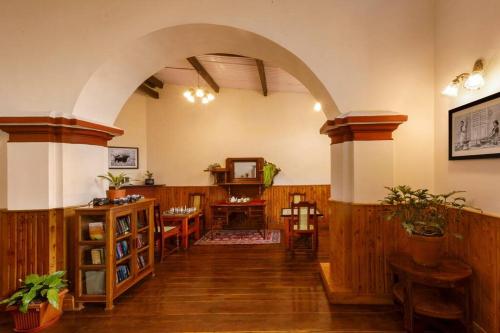 an archway in a room with a table and chairs at Rosewood by Nature Resorts and Stays in Ooty