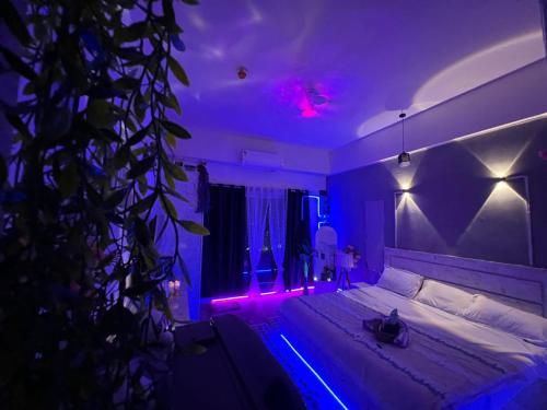 a bedroom with a bed with purple lights on it at GRiK STAY in Greater Noida