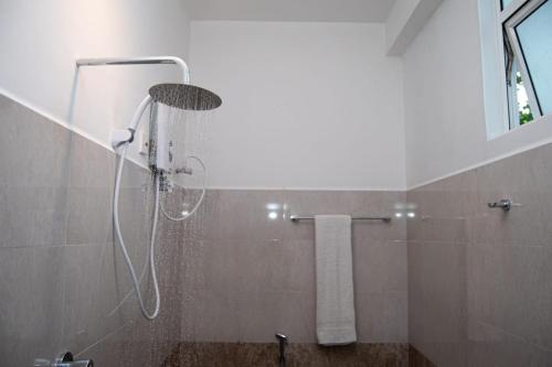 a shower stall in a bathroom with a shower at Rainforest White House in Deniyaya