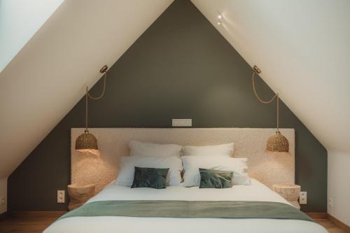 a bedroom with a large white bed with two pillows at L'exclusif douceur in Aubel