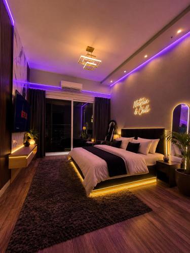 a bedroom with a large bed with purple lighting at Novastay in Greater Noida