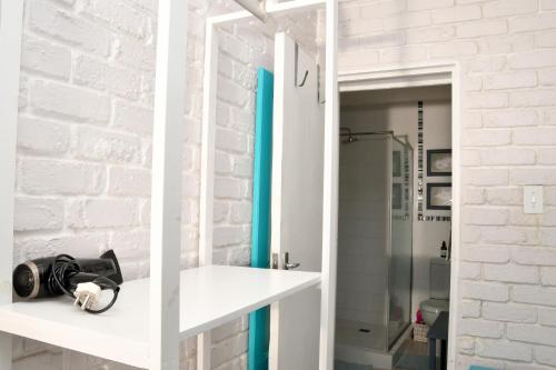 a room with a white brick wall and a mirror at Amazing Grace B&B in Gansbaai