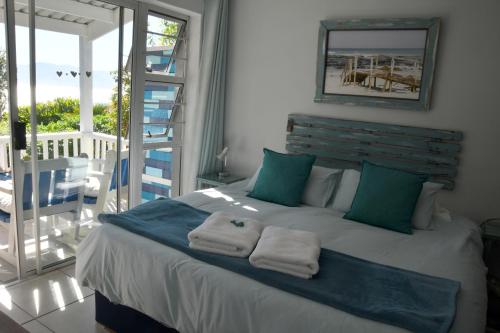 a bedroom with a bed with towels on it at Amazing Grace B&B in Gansbaai