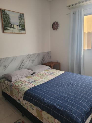 a bedroom with a bed with a blue blanket at Casa Aconchego-Juazeiro do Norte CE Sao Jose in Juazeiro do Norte