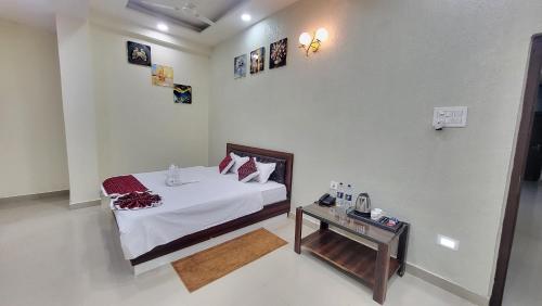 a bedroom with a bed and a table in it at Hotel Adarsh in Khagaul