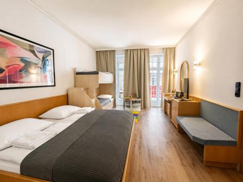 a hotel room with a large bed and a desk at Hotel Borchers in Celle