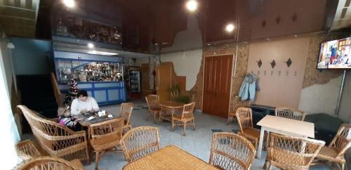 a woman sitting at a table in a restaurant at Кафе Готель Люкс in Tsarivka