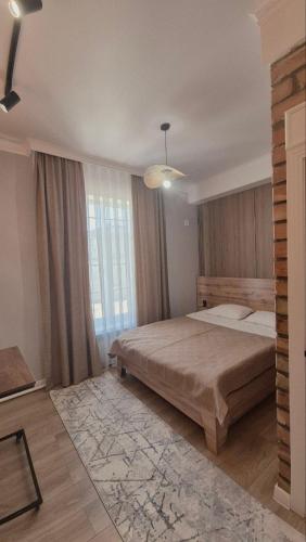a bedroom with a large bed and a large window at Beypil Place in Kochkorka