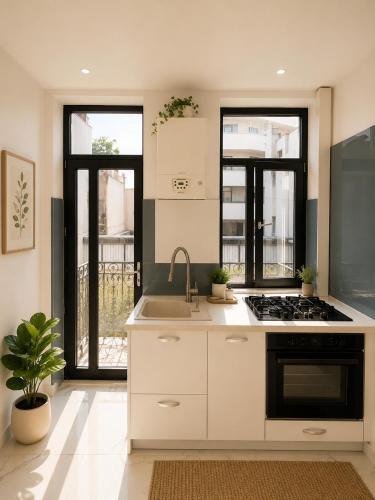 a white kitchen with a sink and a stove at AFY STAYS Boutique Apartments in Bucharest