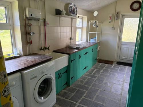 a kitchen with a washer and a washing machine at Glenmore Cottage - Waterville in Waterville