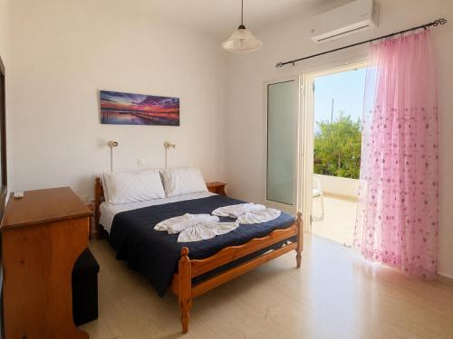 a bedroom with a bed and a large window at Eftichia Apartment in Roda