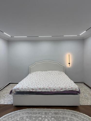 a bedroom with a bed in a white room at Guest House ak orgo in Bishkek