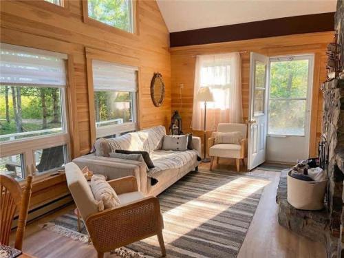 a living room with a couch and some windows at Private Beach Escape - Chalet Ferdinand in Grand Barachois