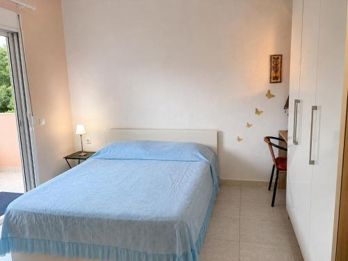 a bedroom with a bed with a blue bedspread at Pefkostalia in Pefkochori