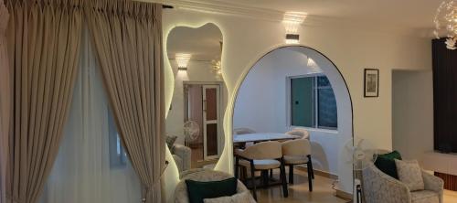 ein Wohnzimmer mit Spiegel, Tisch und Stühlen in der Unterkunft Harrington Duplex in Meran