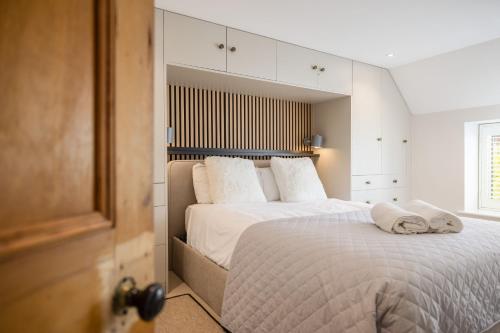 a bedroom with a large bed with white sheets and pillows at Eighteen Pottergate in Helmsley