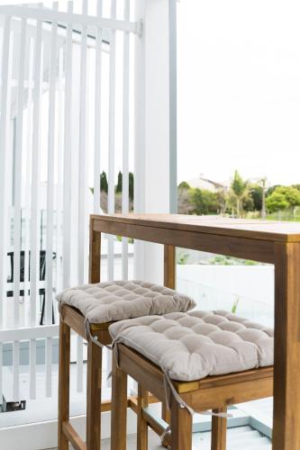 a wooden bench sitting on a porch next to a window at Breakwall Retreat in Manning Point