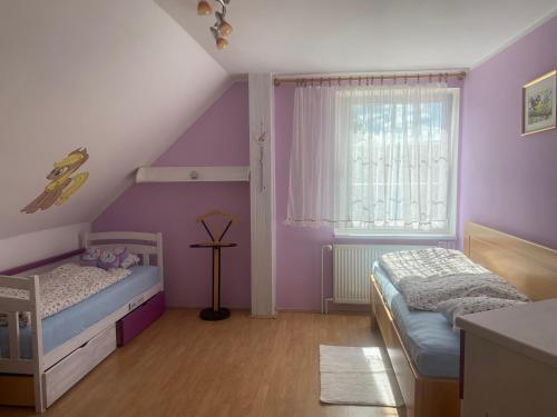 a bedroom with purple walls and a bed and a window at Rodinný dům Na Sibiři in Ledeč nad Sázavou