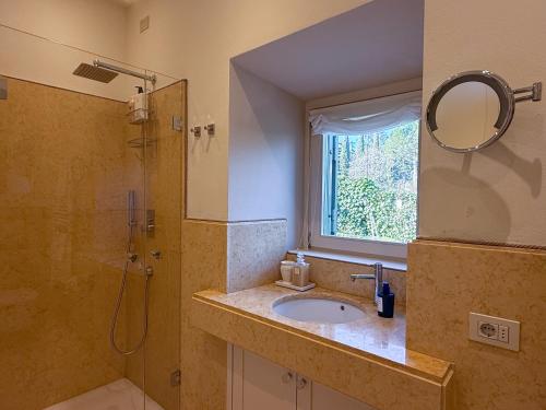 a bathroom with a sink and a shower and a mirror at franciacorta iseo lake house in Clusane sul Lago
