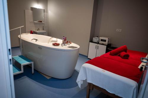 a bathroom with a tub and a bed in it at Salis Hotel & Medical Spa in Turda