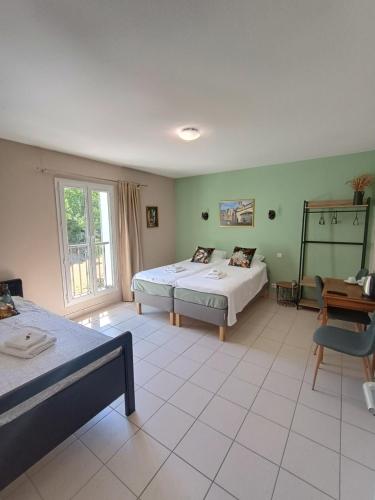 a large room with two beds and a window at Hotel Rêve de la Vallée in Blesle