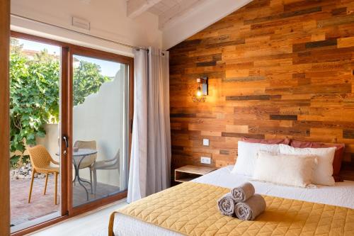 a bedroom with a wooden accent wall at Vida Pura Guesthouse in Odeceixe