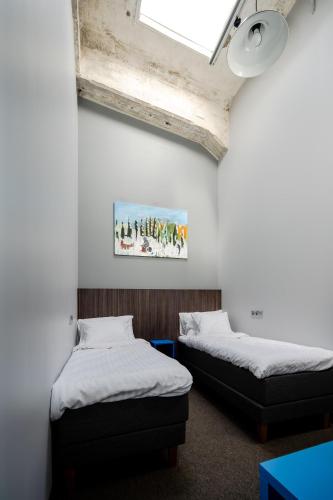 two beds in a room with a ceiling at Viscosa Hotell in Kõrgessaare
