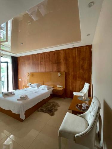 a bedroom with a bed and a table and chairs at New House Kobuleti 2 in Kobuleti
