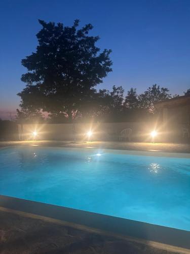 a blue swimming pool at night with lights at Hidden Villa in Klarići
