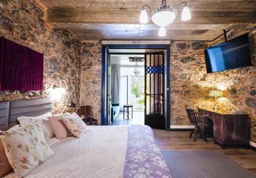 ein Schlafzimmer mit einem Bett und einem Fernseher an der Wand in der Unterkunft Chalet Saudade in Sintra