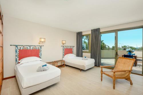 a bedroom with two beds and a balcony at Hotel Villa Undulna - Terme della Versilia in Cinquale