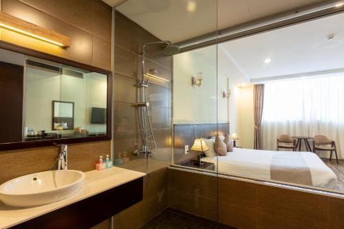 a bathroom with a bed and a sink and a mirror at Lacasa Sapa Hotel in Sapa