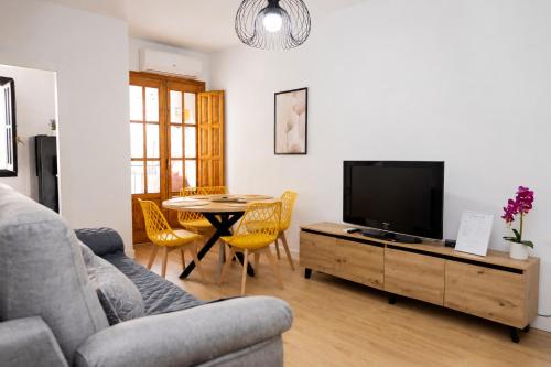 a living room with a couch and a tv and a table at Cazorla a tus pies, en pleno centro con parking in Cazorla
