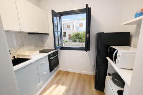 a kitchen with white cabinets and a window at Cazorla a tus pies, en pleno centro con parking in Cazorla