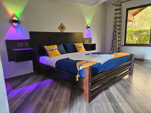 a bedroom with a large bed with purple lights at Lala Inn in Gilgil