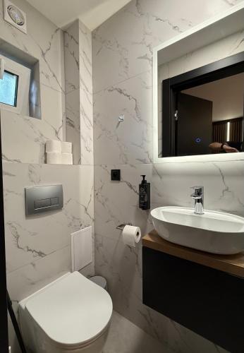a bathroom with a white toilet and a sink at Turawa Lake Residence in Turawa