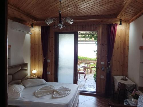 a bedroom with a bed and a sliding glass door at Guest House Bake in Gjirokastër