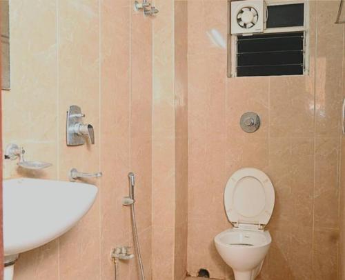 a bathroom with a toilet and a sink at Galaxy Stellar Suites in kolkata