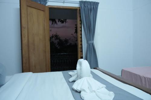 a bedroom with a bed with white towels on it at Cosy Concepts in Kovalam
