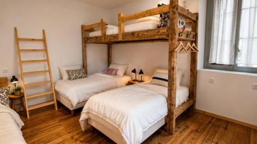 a bedroom with two bunk beds and a ladder at Gîte de l 'Annonciation in Lourdes