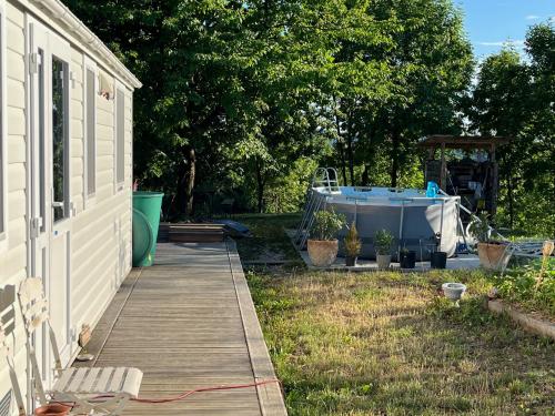 a wooden walkway next to a house with a boat at Romantisches Tiny House mit Pool and Air Condition in Tržec