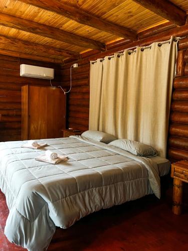 a bedroom with a large bed in a wooden room at Hotel & Restaurant Las Brisas in Puerto Esperanza