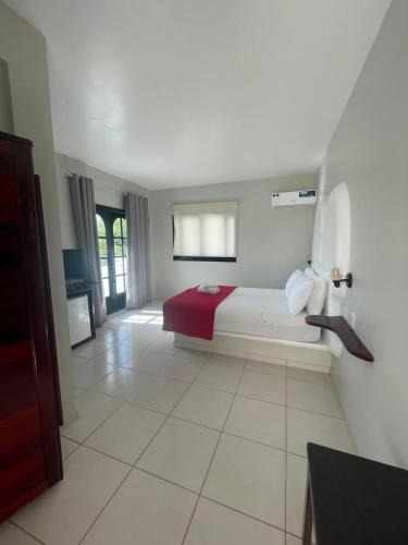 a bedroom with a bed with a red blanket at Villa Veríssimo in Jericoacoara