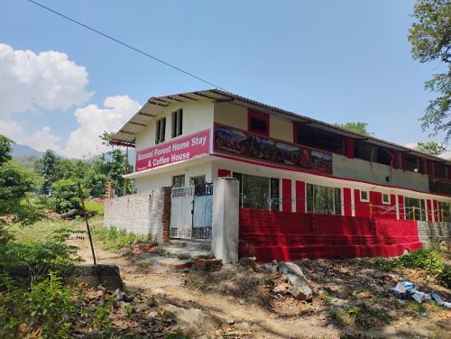 a house with a red fence in front of it at Stay in Forest in Haldwāni