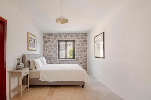 a bedroom with a bed and a brick wall at Rustic Stone House with Spacious Terrace 2BR in Burhaniye