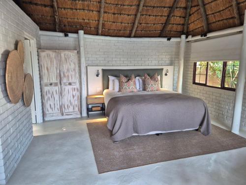 a bedroom with a bed and a brick wall at African Sands B&B in Amanzimtoti