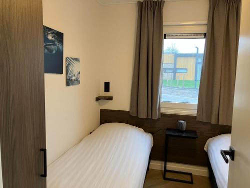 a small bedroom with a bed and a window at Resort Kagerplassen in Warmond