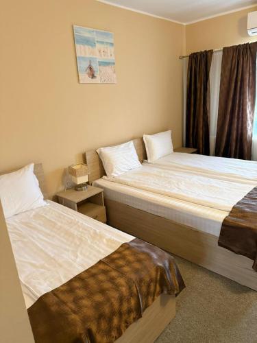 a bedroom with two beds and a window at Hostel Nova Route in Mamaia Sat/Năvodari