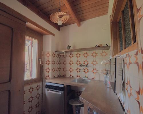 a kitchen with a sink and a refrigerator at Casetta dalle finestre rosse in Bedonia