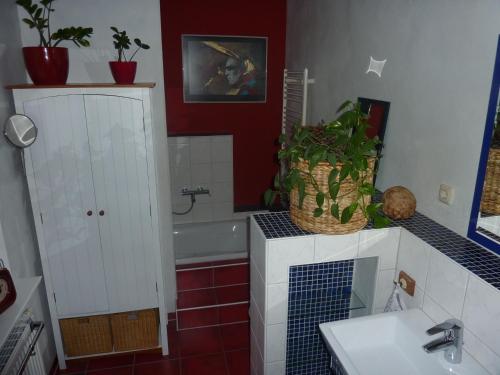 a bathroom with a sink and a bath tub with a plant at La Vita in Ludwigslust